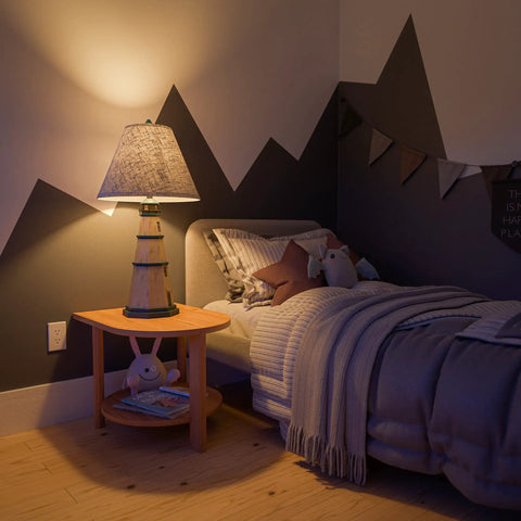 Coastal Nantucket Table Lamp in Antique White Finish, 31 Inch Tall, next to a bed in a cozy nautical-themed room.