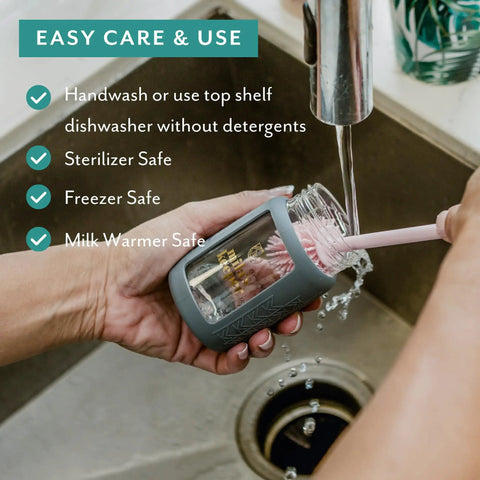 Hand washing Ultra Wide Neck Glass Breast Milk Storage Bottle with BPA free silicone cap in sink.