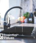 Contemporary kitchen sink faucet with water flow next to flowers, highlighting home decor and functionality.