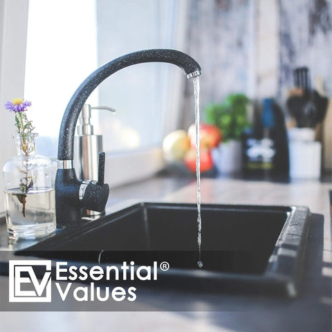 Contemporary kitchen sink faucet with water flow next to flowers, highlighting home decor and functionality.