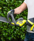 Pro Level 18V ONE PLUS Cordless Hedge Trimmer Featuring 55cm Double Edge Blades And High Output Motor with ergonomic handle in use.