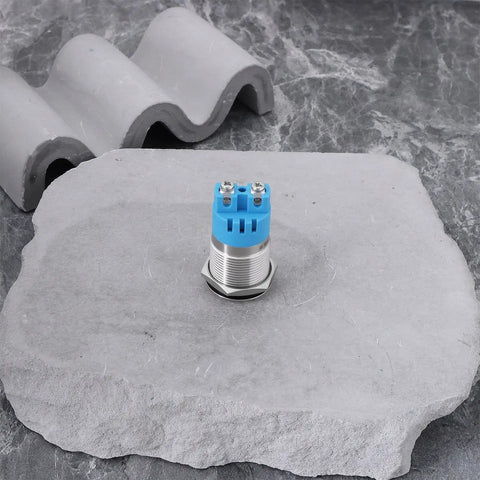Single LED buzzer from Twin Pack 12V IP65 Waterproof LED Flash Buzzer Indicator Light 19mm for electrical panels, placed on stone surface.