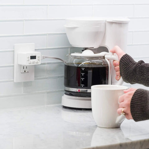 24 Hour Digital Plug Timer With One Polarized Outlet No Fuss Two Programmable On Off Cycles For Lamps And Indoor Lighting 125VAC Indoor Timer White 1 Pack Model 45184 plugged into wall beside a coffee maker.