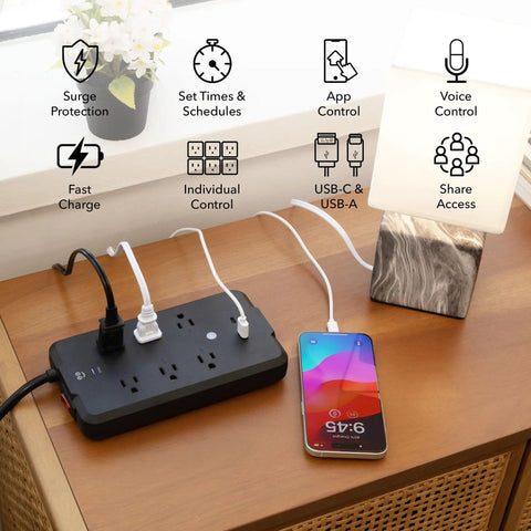 No Fuss Smart Power Strip With Individual Outlet Control, Rock Solid Surge Protection, Dual Fast Charging Usb A And C Ports, Straight Ahead Cable Management For Home Or Gaming Setup Black on a wooden table with a phone charging.