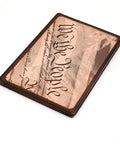 Copper card etched with 'We the People' text, showcasing a unique design on a flat, rectangular surface.