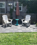 Interlocking Patio Deck Tiles 12x12 Inch Square Composite Plastic Outdoor Flooring For Balcony Porch Backyard All Weather Four Slat Non Slip Tiles Dark Brown Pack Of 27 in a garden setting with two white chairs and a blue table.