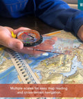 Person using Liquid Filled Compass Kit For Hiking With Trail Ready Rotating Bezel, Quick Tip Guide, And Carabiner over a map