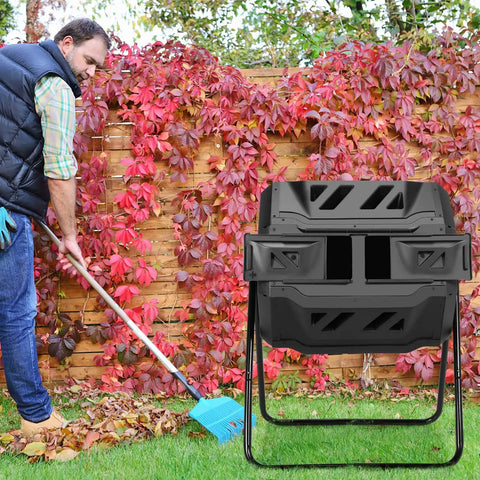 43 Gallon 163L Dual Chamber Compost Tumbler With Sliding Doors And Stable Metal Frame in garden setting with person raking leaves