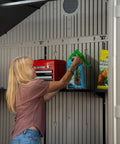 Woman organizing items inside Desert Sand Outdoor Storage Shed 15x8 Ft Resin Backyard Tool Shed With Lockable Doors UV Protected Panels.