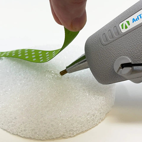 Two Temp Dual Temperature Hot Glue Gun, Full Size, Light Gray, shown gluing ribbon to foam, precision nozzle in use
