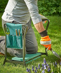 Person using 2 In 1 Portable Garden Kneeler Bench And Seat Stool With Tool Bag Accessory and folding steel frame in garden