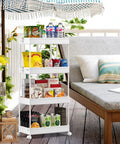 4 Tier Rolling Storage Cart Great For Tight Spaces On Wheels A Mobile Shelving Unit For Kitchen Bathroom Laundry Room Living Room Office Space Saver White next to a lounge chair on a patio.