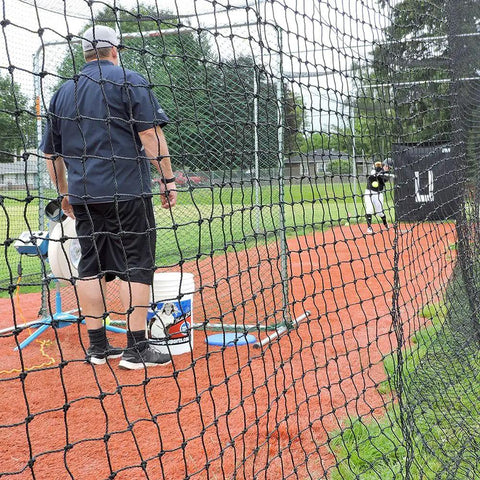 Coach and player in baseball and softball batting cage net for backyard setup, 60 twisted knotted black polyethylene with hitters door.