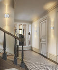 Gold Bubble Crystal Wall Sconce With LED Vanity Light in hallway, warm glow, mounted on a white wall near staircase