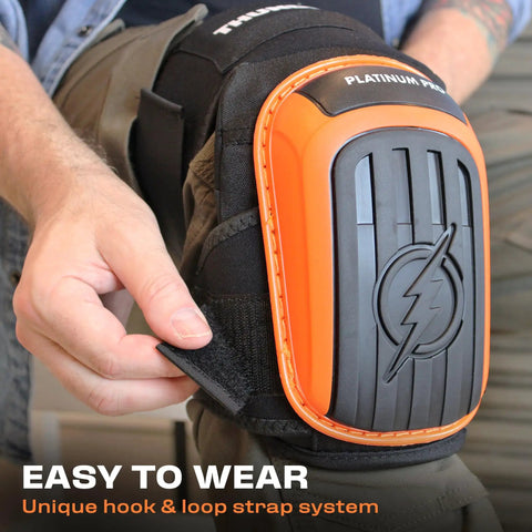 Heavy Duty Knee Pads For Work And Home Use With Double Gel Comfort Extra Thick Foam Adjustable Non Slip Straps Ideal For Construction Gardening Flooring Roofing And More For Men And Women with orange and black design, person adjusting straps.