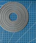 12pc Nesting Round Frame Die Cut Set for Cards and Scrapbooking, Lace Circle Tag Background Dies on blue grid mat