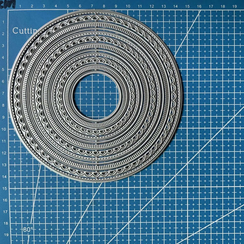 12pc Nesting Round Frame Die Cut Set for Cards and Scrapbooking, Lace Circle Tag Background Dies on blue grid mat