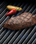 Rock Solid Porcelain Coated Cast Iron Grill Grates Replacement For Broil King Baron And Crown Series grilling steak on black grid.