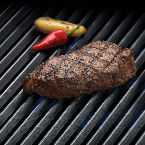 Rock Solid Porcelain Coated Cast Iron Grill Grates Replacement For Broil King Baron And Crown Series grilling steak on black grid.