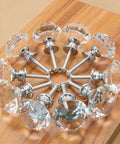 100 Pack Clear Acrylic Cabinet Handles With Zinc Alloy Base 30mm Crystal Drawer Pulls arranged in circle on wood background.