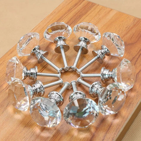 100 Pack Clear Acrylic Cabinet Handles With Zinc Alloy Base 30mm Crystal Drawer Pulls arranged in circle on wood background.