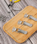 Stainless Steel Spring Loaded Toggle Latch Set Four Pack With Screws Heavy Duty Metal Locking Latch on wooden tray with screws