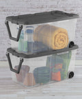 Rugged Pull Along 160 Quart Rolling Storage Tote With Transparent Bottom showcasing stacked clear crates filled with various items.