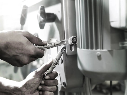 Close-up of Joker SB Ratcheting Combination Wrench Nine Sixteenths Inch Open End Hold With Depth Stop in use on machinery
