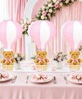 Bear Themed Hot Air Balloon Centerpiece Kit For Baby Shower And Gender Reveal With 6 Pink Paper Lanterns displayed on a decorated table.