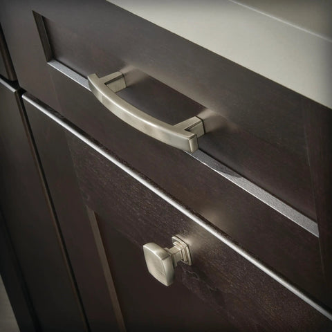 Close-up of Premium Brushed Nickel Cabinet Knobs and handles on dark wooden drawers in a kitchen setting.