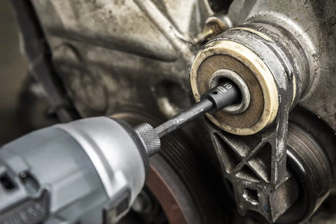 Impact wrench using a 48 Piece Quarter Inch Drive 6 Point Impact Socket Set Standard And Deep SAE And Metric With Off Corner Loading on an engine.