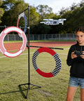 Girl flying quadcopter through gates from Outdoor Drone Obstacle Course Kit For FPV Racing Indoor Quadcopter Gates For Beginner Friendly Practice DIY Gate Set To Build Custom Race Routes And Multiplayer Challenges.