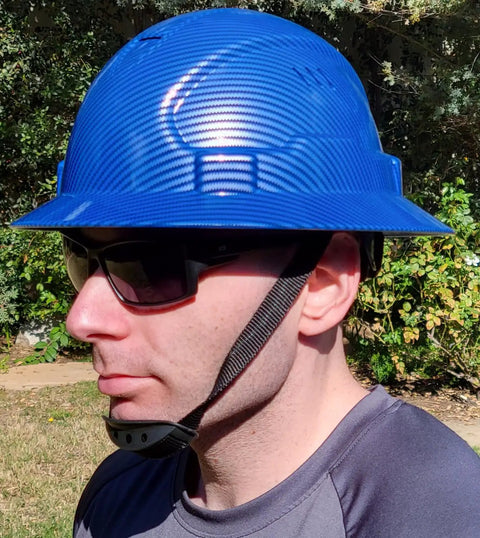 Man wearing blue All Day Comfort Full Brim Construction Hard Hat OSHA Approved Vented Safety Helmet with 6 Point Ratchet Chin Strap.