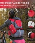 AL21 red all-purpose first aid kit pouch attached to a bike rider's backpack during a ride