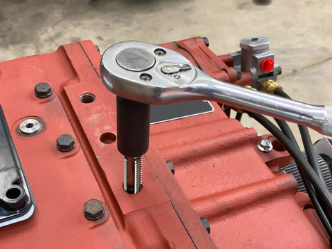 Using Five Piece Large Tap Socket Set For Auto Repairs Includes Five Large Tap Sockets In Five Eighths Inch on engine block.