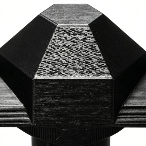 Close-up of Durable Universal Fit Lawn Spreader Replacement Part with Pro Grade Anti Clog Mechanism, showing textured black surface.