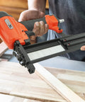 Real Deal Air Brad Nailer With Quick Release Bottom Load Magazine And 1000 18G Type 180 Brads To Knock Out Woodworking Projects In Bold Orange Carry Case held over wooden boards.