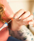 Person using Quilling Bead Roller Tool Set with Slotted Winding Pins in Three Sizes for DIY paper jewelry making.