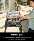 Person using Woodfire Pro Connect Deluxe XL Backyard Grill and Smoker With Bluetooth App Control on patio, grilling food