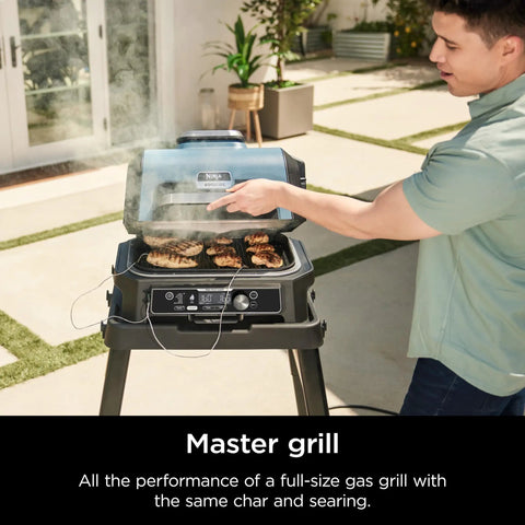 Person using Woodfire Pro Connect Deluxe XL Backyard Grill and Smoker With Bluetooth App Control on patio, grilling food