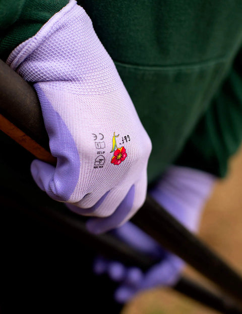 Women Gardening Gloves With Micro Foam Palm Coating And Textured Grip For Weeding Digging Raking And Pruning, holding a garden tool.