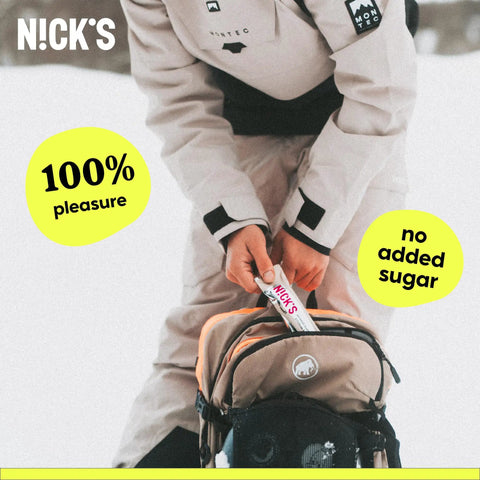 Person placing N!CK'S protein bar into a backpack, emphasizing "100% pleasure" and "no added sugar" as product features.
