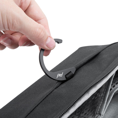 Hand holding hook of Small Wash Pouch Travel Toiletry Bag Weatherproof With Upright Or Hanging Design, Wide UltraZip Opening shown