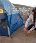 Securing Late Start 2P Backpacking Tent for Two People with stakes in outdoor setting