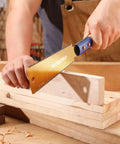 Kickass Six Inch Japanese Pull Saw Featuring Double Edged Design With Fourteen Teeth Rip Side And Seventeen Teeth Cross Cut Blades For Slick Precision Woodworking And Pro Grade Carpentry Projects in use cutting a wood plank.