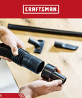 Hands connecting 2.5 Inch To 1.25 Inch Vacuum Hose Reducer Adapter For Wet Dry Vac And Shop Vac Accessories on a workbench.
