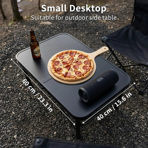 Ultra Portable Camping Table With Aluminum Frame holding pizza, speaker, and drink, outdoor setting, 60 cm by 40 cm size.
