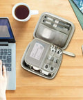 Hard Shell Cable Tech Organizer Travel Case For Power Banks And Portable Chargers With Straight Up Cable Organization And Kickass Gadget Protection Optimized To Keep Essentials Snug And Secure On Every Trip White opened with tech gear on a wooden desk.