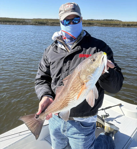 Angler holding redfish caught using 4 Inch Soft Plastic Paddle Tail Swimbaits Pack Of 12 Electric Green With Realistic Kicking Action