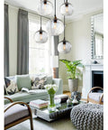 Living room with four hand blown glass pendant lights over kitchen island with seeded bubbles globe lamp, clear 8.7 inch diameter.